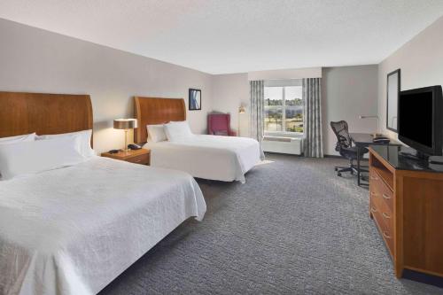 麦迪逊杰克逊-麦迪逊希尔顿花园酒店的酒店客房设有两张床和一台平面电视。