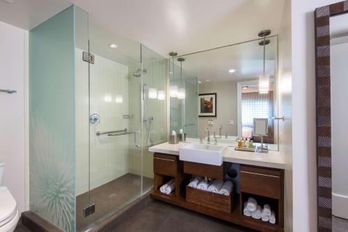 瓦克拉Hilton Grand Vacations Club Kings Land Waikoloa的一间带水槽和玻璃淋浴的浴室