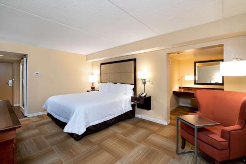 拉法叶拉斐特汉普顿酒店的配有一张床和一把椅子的酒店客房