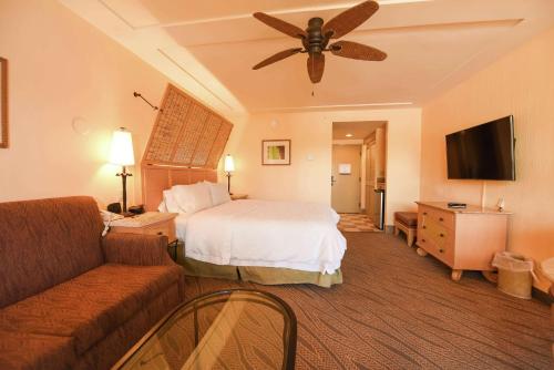 基拉戈基拉戈希尔顿恒庭酒店的酒店客房配有床、沙发和吊扇。