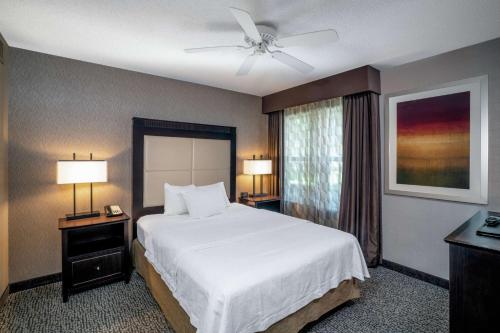 拉法叶拉斐特希尔顿惠庭套房酒店的卧室配有白色的床和吊扇