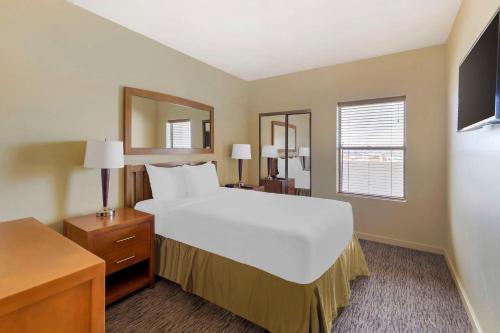 拉斯维加斯Hilton Vacation Club Cancun Resort Las Vegas的卧室配有一张白色大床和镜子