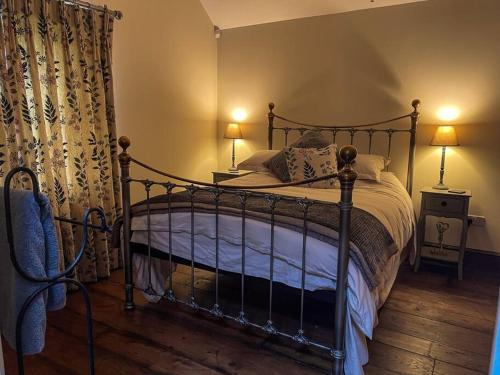 DonyattThe Udderhouse - Udderly Unforgettable Retreat的一间卧室配有一张床、两盏灯和窗帘