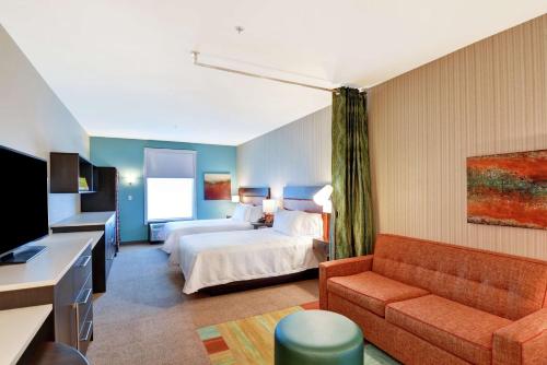 拉斯维加斯拉斯维加斯大道南希尔顿欣庭套房酒店的酒店客房,配有床和沙发