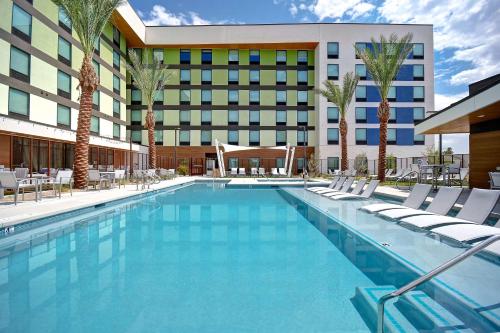 拉斯维加斯Home2 Suites by Hilton Las Vegas Convention Center - No Resort Fee的一个带椅子的游泳池和一间酒店