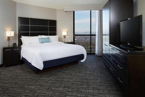 洛杉矶洛杉矶国际机场北使馆套房酒店的一间卧室配有一张大床和一台平面电视