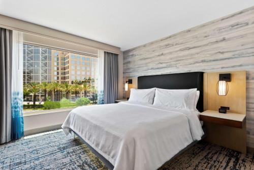 安纳海姆Embassy Suites by Hilton Anaheim South的一间卧室设有一张大床和一个大窗户