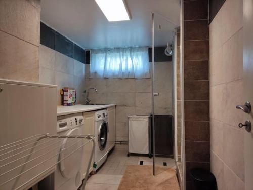 默恩达尔90 m2 charmig källarlägenhet nära natur och stad的厨房配有洗衣机和淋浴。