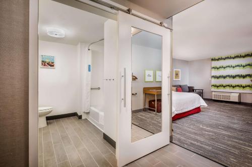 帕拉默斯Hampton Inn By Hilton Paramus的一间带镜子和床的卧室以及一间浴室