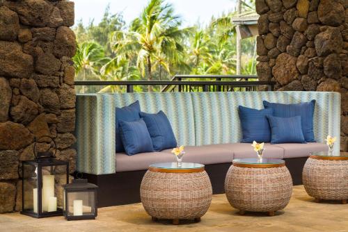 卡帕阿考艾岛怀卢阿湾希尔顿花园酒店，HI的天井配有带蓝色枕头和蜡烛的沙发。