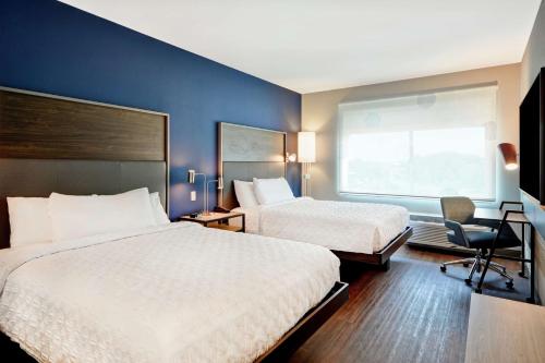 DenverTru By Hilton Denver, PA的酒店客房设有两张床和窗户。