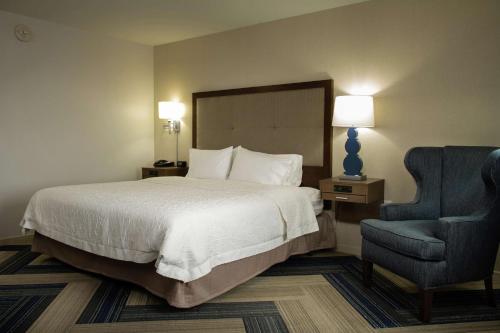 拉克罗斯拉克罗斯市中心汉普顿套房酒店的酒店客房,配有一张床和一张蓝色椅子