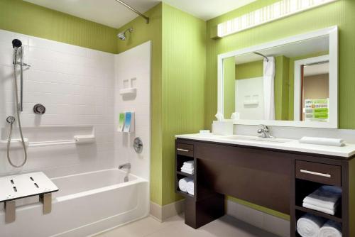 莱温芙丝Home2 Suites By Hilton Leavenworth Downtown的带浴缸、水槽和镜子的浴室