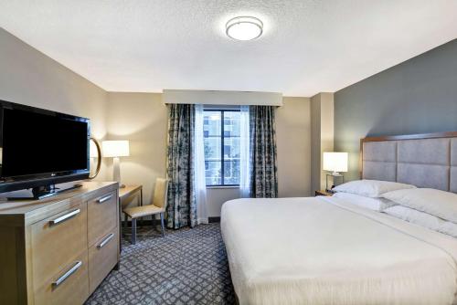 奥兰多Embassy Suites by Hilton Orlando Downtown的配有一张床和一台平面电视的酒店客房
