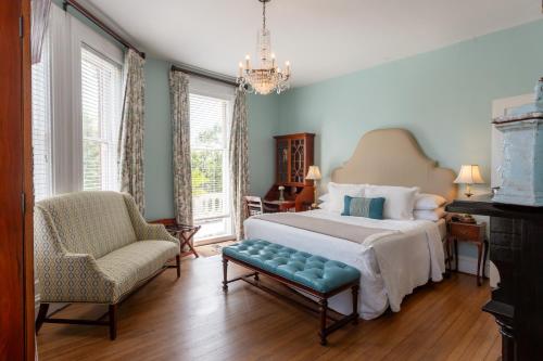 萨凡纳Kehoe House, Historic Inns of Savannah Collection的一间卧室配有一张床、一把椅子和窗户。