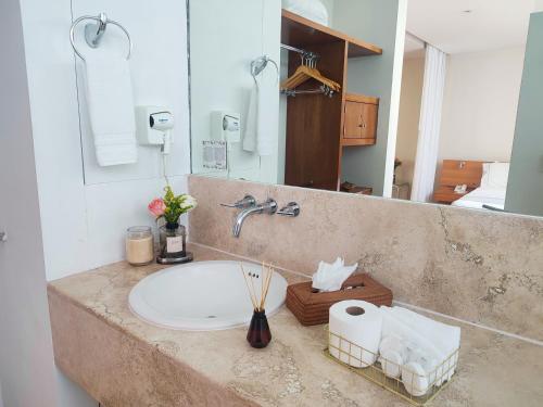 墨西哥城隆巴多套房的浴室的柜台设有水槽和镜子