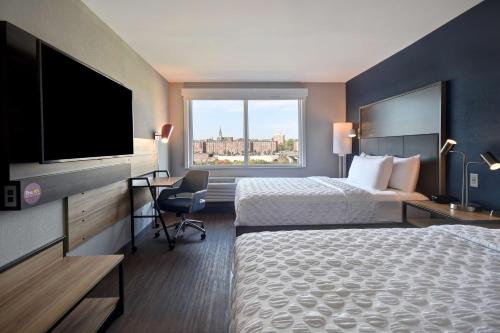 曼切斯特Tru By Hilton Manchester Downtown的酒店客房设有两张床和一台平面电视。
