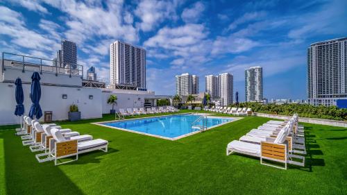 迈阿密迈阿密市区希尔顿酒店的一个带白色躺椅的游泳池,一个度假胜地