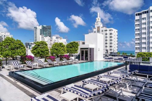 迈阿密海滩Gale South Beach, Curio Collection By Hilton的一座带躺椅的建筑屋顶上的游泳池