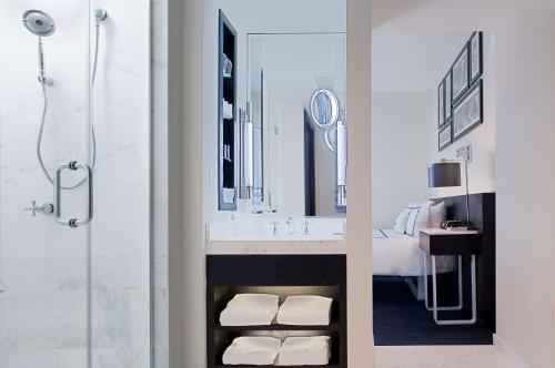 迈阿密海滩Gale South Beach, Curio Collection By Hilton的带淋浴和盥洗盆及镜子的浴室