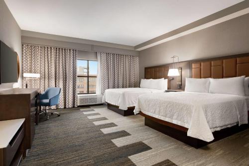 堪萨斯城Hampton Inn Suites Kansas City Downtown Crossroads的酒店客房配有两张床和一张书桌