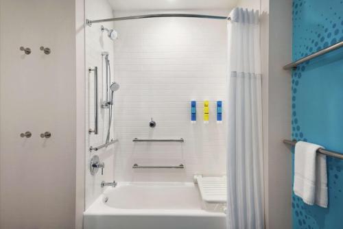 沃科夏Tru By Hilton Milwaukee Brookfield的白色的浴室设有浴缸和淋浴。