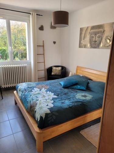 南特Welcome的一间卧室配有一张带蓝色床单的床和一扇窗户。