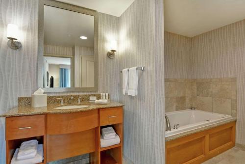 达夫尼莫比尔东湾/达芙妮惠庭酒店的一间带水槽、浴缸和镜子的浴室
