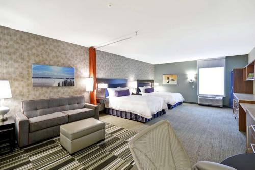 明尼通卡Home2 Suites By Hilton Minneapolis-Eden Prairie的酒店客房,设有两张床和一张沙发