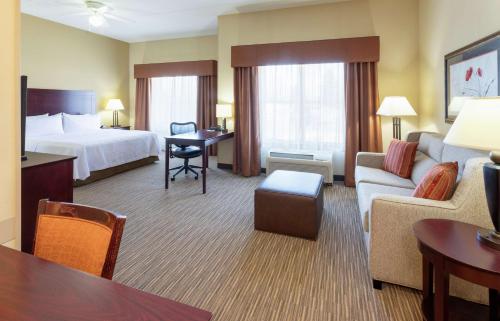 圣路易斯帕克明尼阿波里斯希尔顿惠庭套房酒店 - 西区圣路易斯帕克的酒店客房设有床和客厅。