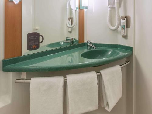 贝桑松ibis Besançon Centre la City的一间带绿色水槽和毛巾的浴室