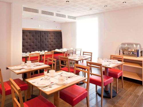 维泰勒维泰勒美居酒店的餐厅设有木桌和红色椅子