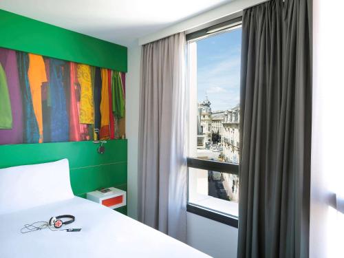 蒙彼利埃蒙彼利埃喜剧中心宜必思尚品酒店的一间卧室设有一张床和一个美景窗户。