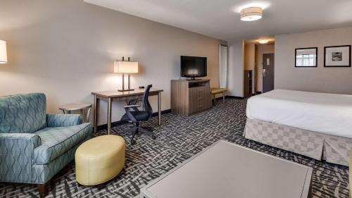 杜波依斯Best Western DuBois Hotel的酒店客房配有一张床、一张沙发和一张书桌。