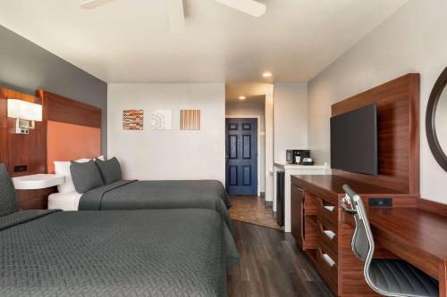 迪波湾Travelodge by Wyndham Depoe Bay的酒店客房设有两张床和一台平面电视。
