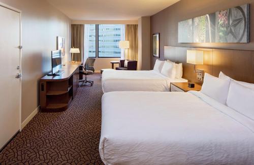 达拉斯达拉斯市中心希尔顿花园酒店的酒店客房配有两张床和一张书桌