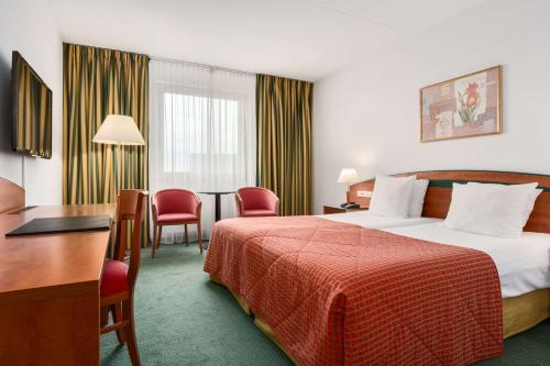 马斯特里赫特马斯特里赫特NH酒店的酒店客房带一张床、一张桌子和椅子