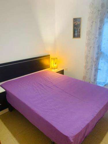 卡拉费尔Habitación privada的白色客房内的大紫色床