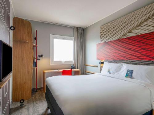 特鲁希略ibis Trujillo的酒店客房设有一张大床和一台电视。