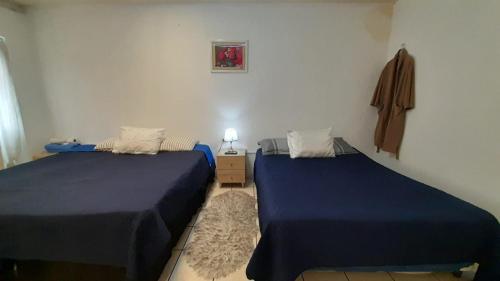 危地马拉Hotel Bluehouse的配有蓝色床单的客房内的两张床