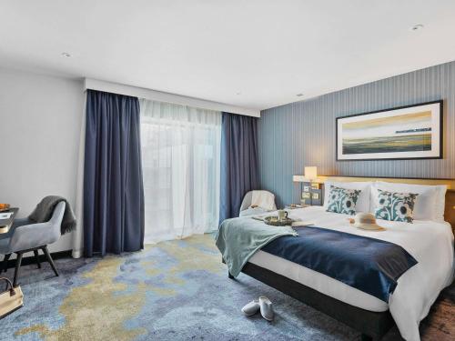 佩恩顿Mercure Paignton Hotel的酒店客房设有一张大床和一张书桌。