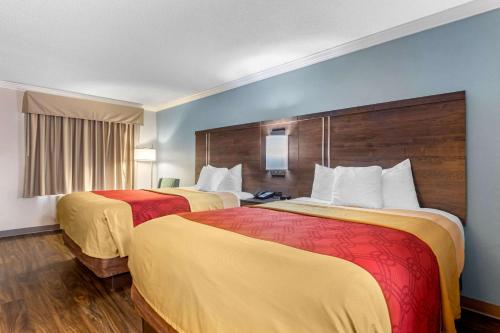 拜伦Econo Lodge Byron - Warner Robins的酒店客房带两张黄色和红色的床铺