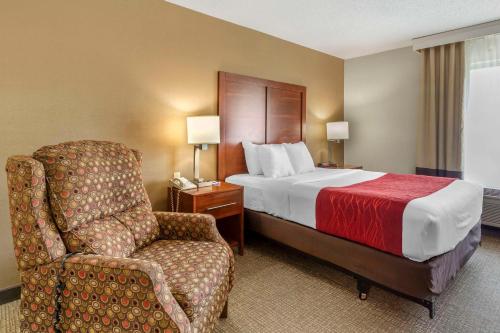 拉皮德城Comfort Inn & Suites的配有一张床和一把椅子的酒店客房