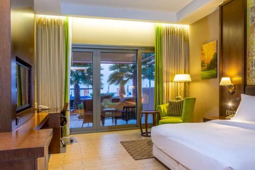 索哈尔Radisson Blu Hotel & Resort, Sohar的酒店客房设有一张床,享有庭院的景色