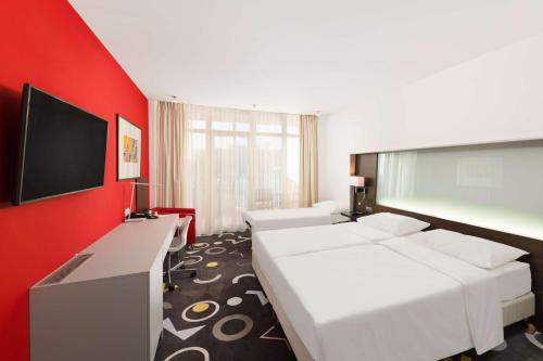 萨尔瓦尔Park Inn by Radisson Sarvar Resort & Spa - All Inclusive的酒店客房设有两张床和一台平面电视。