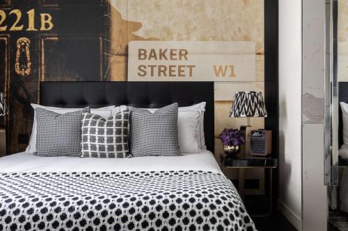 伦敦Holmes Hotel London的卧室配有带枕头的黑白床。