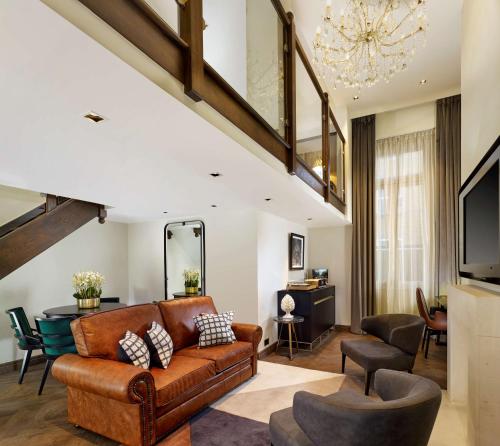 伦敦Holmes Hotel London的客厅配有棕色的沙发和椅子