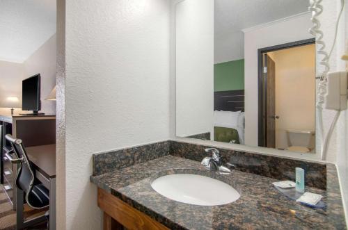 RussellQuality Inn的一间带水槽和大镜子的浴室