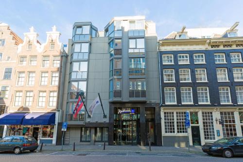 阿姆斯特丹Radisson Blu Hotel, Amsterdam City Center的城市街道上一座高大的建筑,有建筑