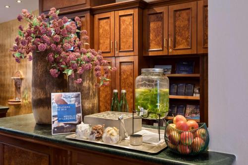 萨尔茨堡老生蓝色丽笙酒店的花瓶和一碗水果的柜台